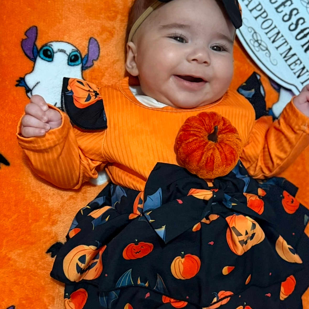 Emine joined the competition — help win amazing prizes! baby, baby_girl, bat, black_skirt, blanket, cartoon_ghost, celebration, costume, cute, festive, halloween, happy, headband, indoor, infant, lying_down, orange_clothing, patterned_clothing, pumpkin, smiling