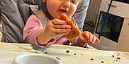 Kaïssy participe au concours pour gagner de l'argent avec cette photo : toddler, child, high_chair, food, biscuit, messy, kitchen, indoor, cute, curly_hair, pink_clothing, socks, table, tray, seatbelt, young_child, person, baby, snack, home