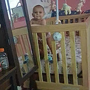 Bryson joined the competition — help win amazing prizes! baby, crib, wooden_crib, mobile, plush_toys, mirror, calendar, pink_wall, floor, indoor, child, toy, furniture, reflection, person, standing, diaper, room, curious, calm