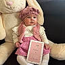 Rose a rejoint le concours — aidez-le/la à gagner de superbes lots ! baby, child, plush_toy, bunny, pink_skirt, pink_hat, milestone_card, white_tights, white_socks, couch, indoor, portrait, cute, infant, soft_toy, seated, cozy, smiling, decor, person
