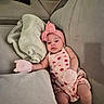 baby, infant, couch, blanket, mittens, headband, pink_clothing, socks, person, indoor, furniture, relaxing, cute, portrait, child, young_child, comfortable, resting, soft_toys, home