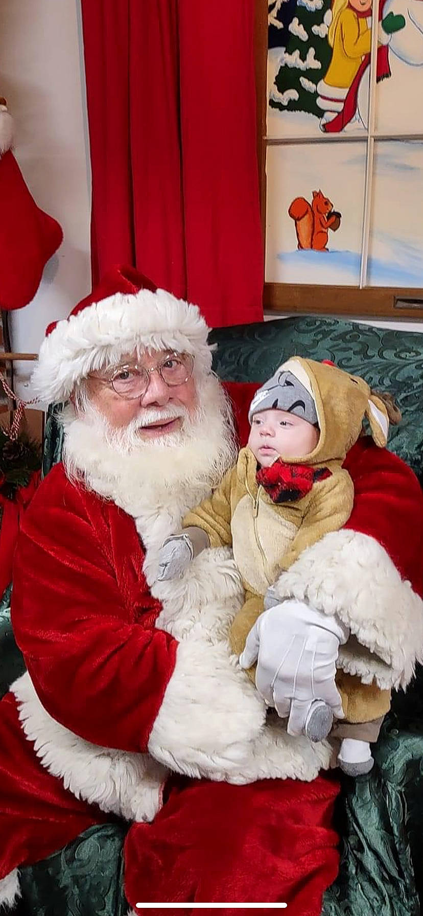 Julian joined the competition — help win amazing prizes! beard, christmas, christmas_eve, curtain, event, facial_hair, fictional_character, fun, fur, fur_clothing, happy, hat, headwear, holiday, lap, person, red, santa_claus, sitting, smile