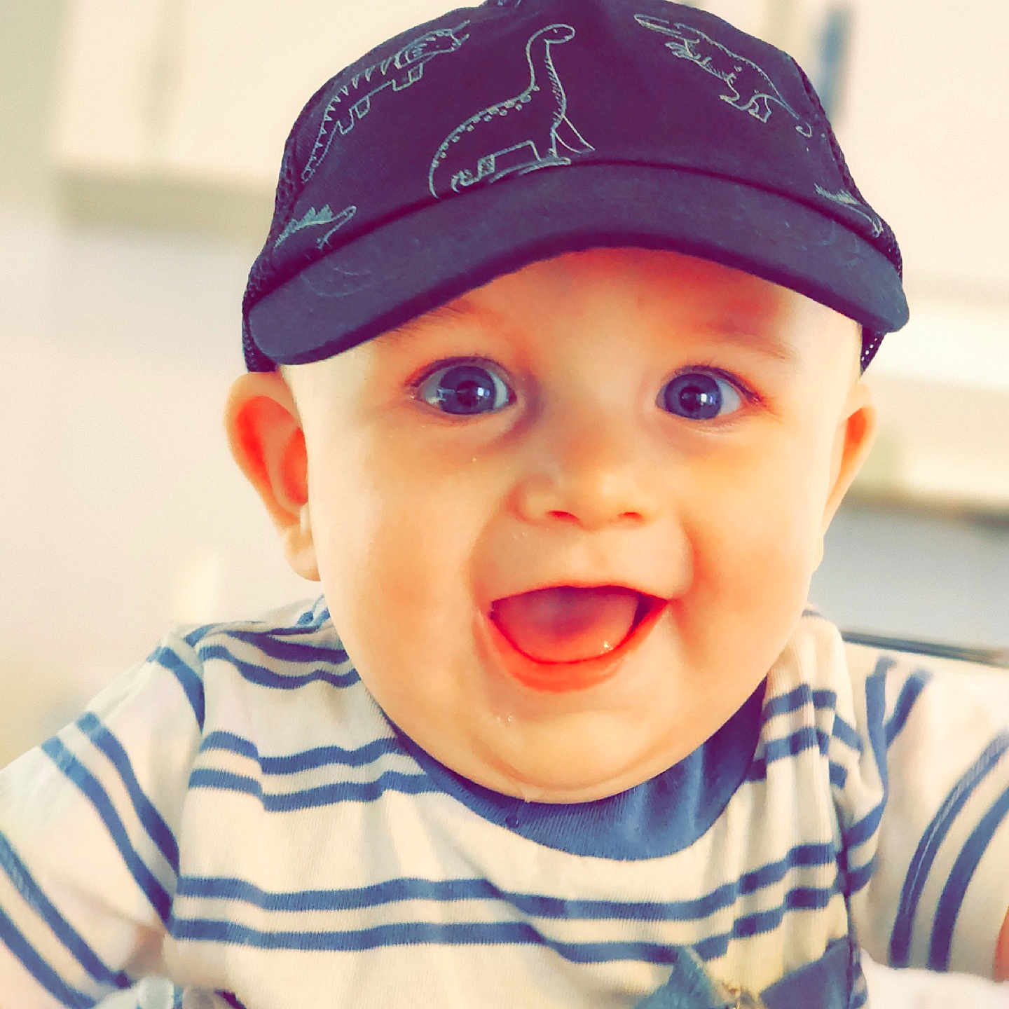 Aric joined the competition — help win amazing prizes! baby, blue_eyes, cap, casual, child, clothing, cute, dinosaur_pattern, expression, face, happy, hat, headwear, indoor, joy, person, portrait, smiling, striped_shirt, toddler