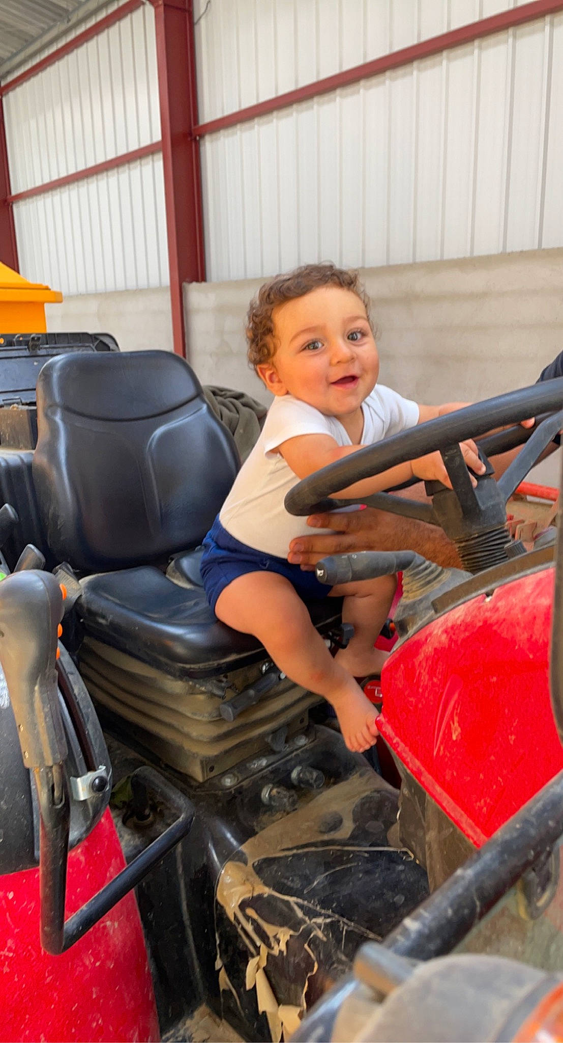Esteban participe au concours pour gagner de l'argent avec cette photo : auto_part, automotive_design, automotive_exterior, automotive_tire, automotive_wheel_system, bumper, child, fun, hood, human_leg, leg, leisure, motor_vehicle, person, shorts, smile, thigh, toddler, tractor, vehicle_door
