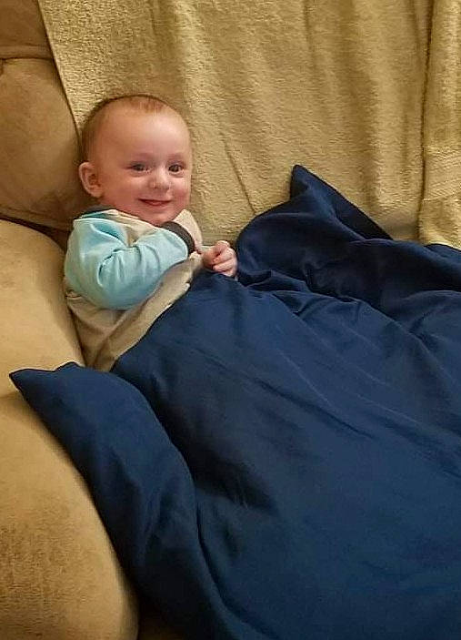 Logan joined the competition — help win amazing prizes! baby, baby_products, baby_toddler_clothing, bedding, bedtime, cheek, child, comfort, fun, human_leg, joy, lap, linens, nap, person, room, sitting, sleep, sleeve, smile