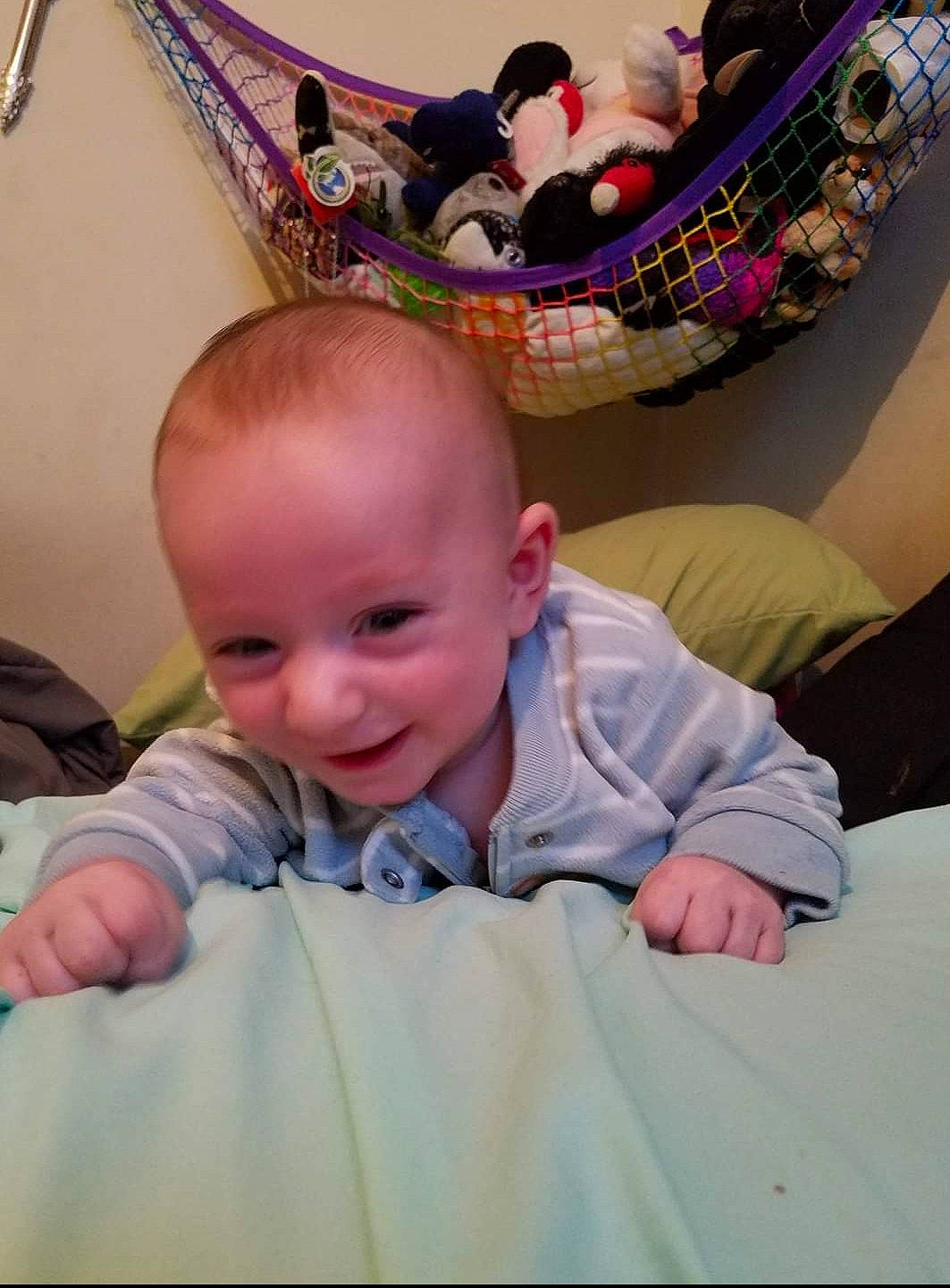 Logan is registered to the contest to win money with this photo: baby, cheek, child, comfort, eye, facial_expression, flooring, fun, hairstyle, happy, head, iris, joy, leisure, mammal, person, pink, sitting, skin, smile