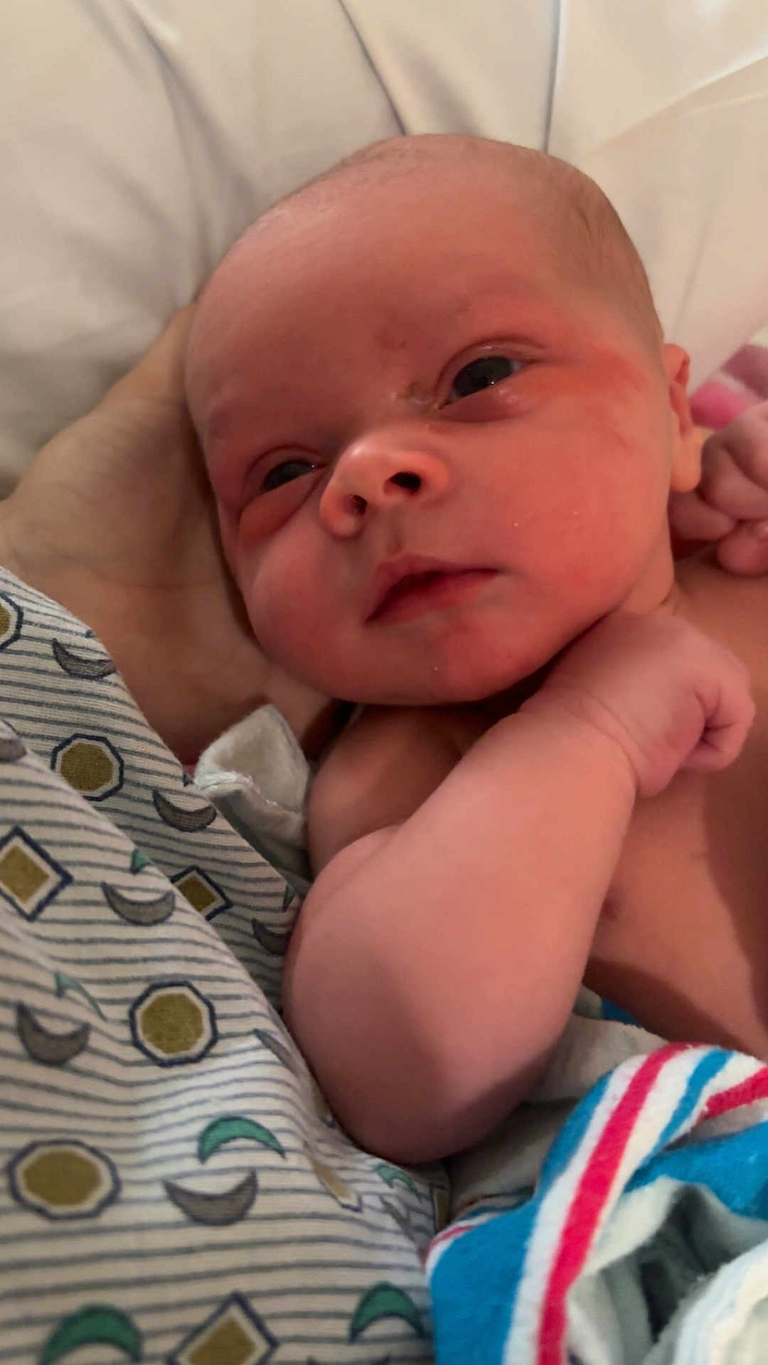 Elliot joined the competition — help win amazing prizes! newborn, baby, infant, close_up, hand, blanket, skin, face, eyes, arm, person, bed, rest, sleepy, soft_lighting, newborn_clothing, comfort, caring, family, child