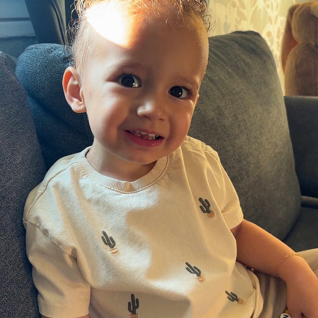 Gabin a rejoint le concours — aidez-le/la à gagner de superbes lots ! accessories, baby, blonde, chair, clothing, couch, cushion, face, furniture, hair, happy, head, homedecor, pants, person, photography, portrait, sitting, smile, t_shirt