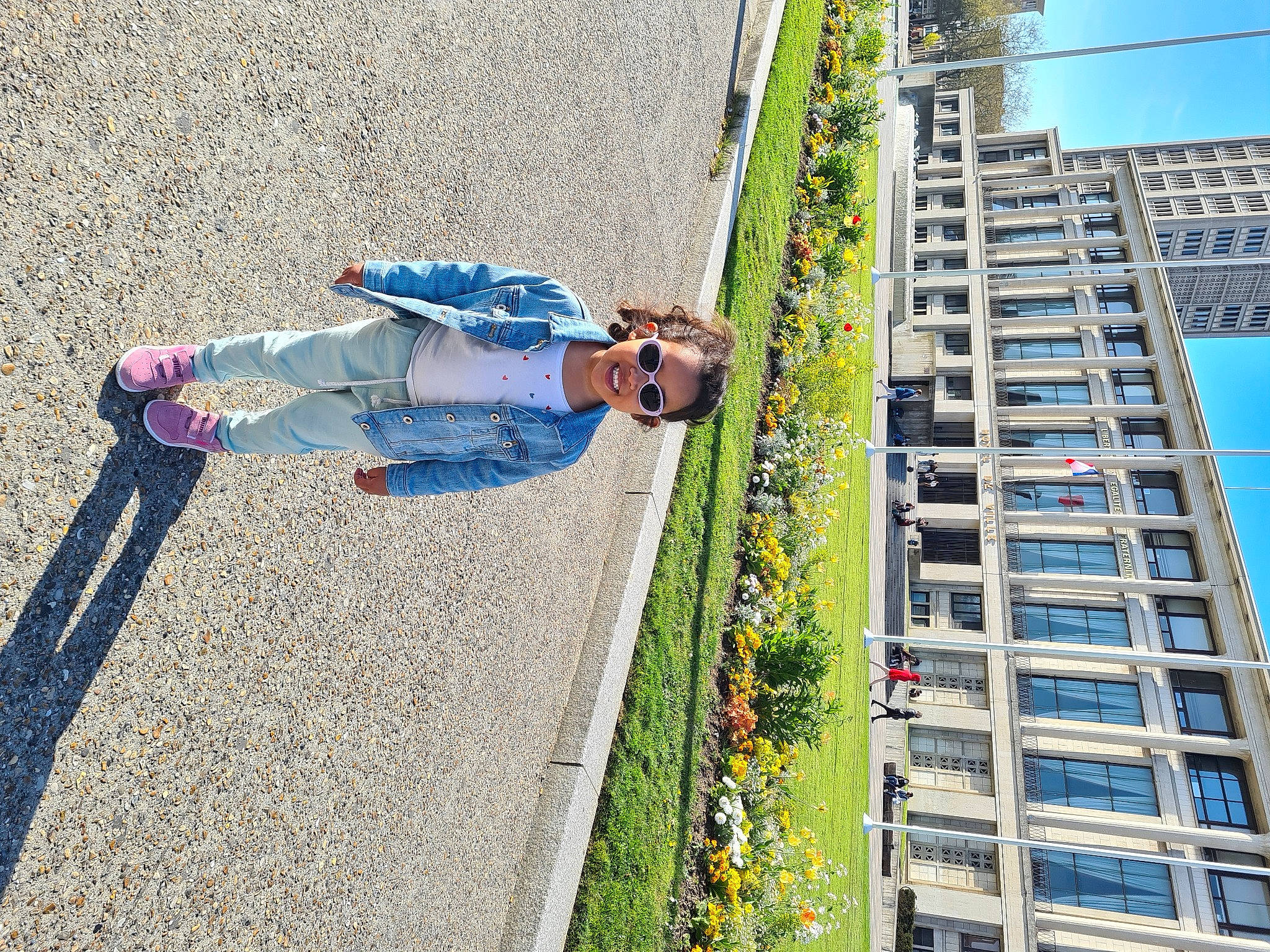 Kayla participe au concours pour gagner de l'argent avec cette photo : asphalt, building, city, daytime, denim, electric_blue, facade, flower, fun, human_settlement, joy, leisure, pedestrian, person, plant, road, road_surface, sidewalk, sky, street