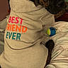 Bruno is registered to the contest to win money with this photo: dog, brindle, hoodie, clothing, pet, bed, indoor, toy, ball, cozy, cute, animal, looking_back, fabric, casual, friendship, resting, comfort, furniture, canine