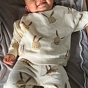 Maël a rejoint le concours — aidez-le/la à gagner de superbes lots ! baby, child, smile, pajamas, bunny_pattern, blanket, lying_down, cozy, cute, infant, soft_texture, happy, indoors, comfortable, socks, small_hands, head, face, relaxed, toddler
