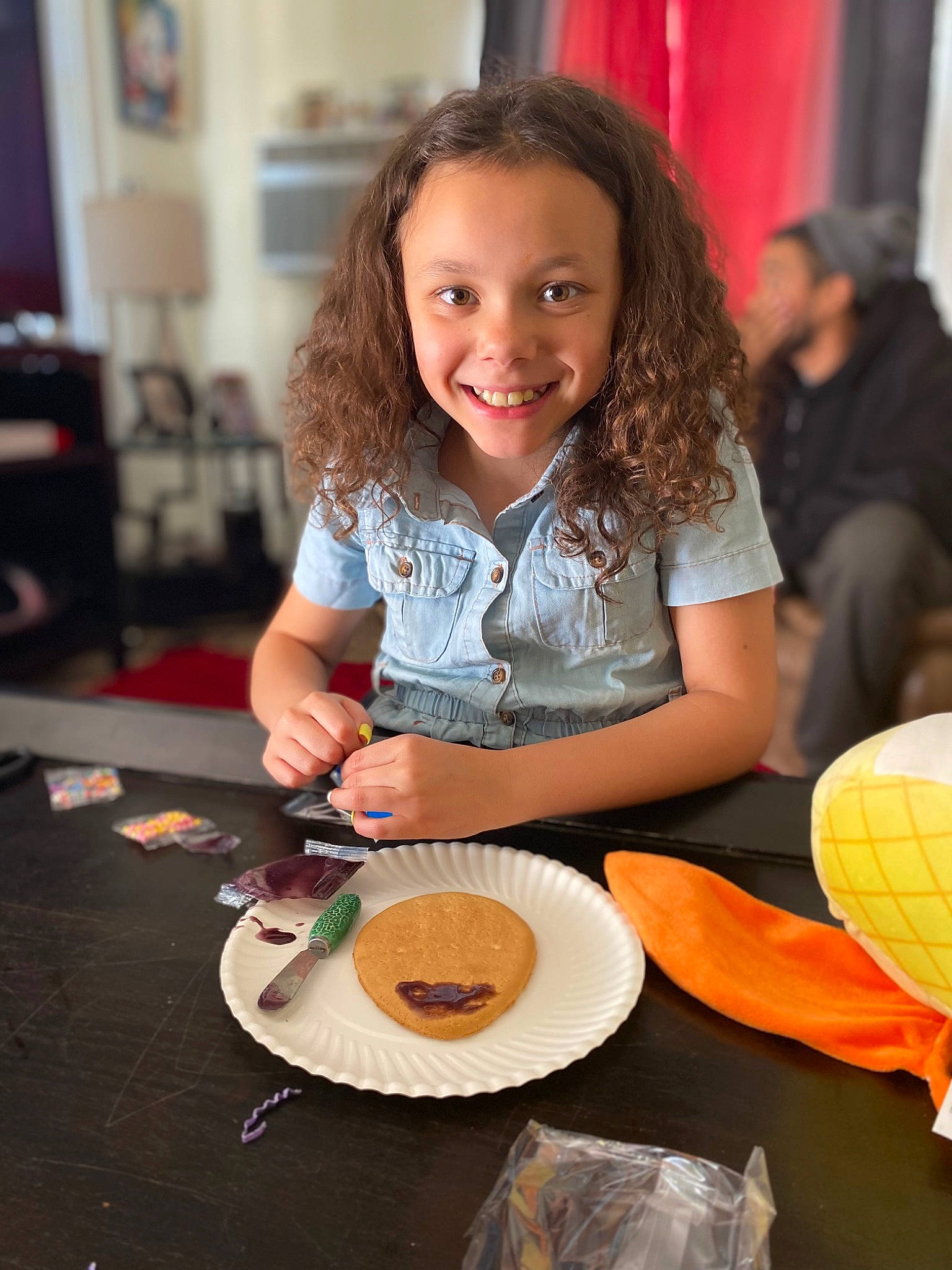 Kaleena joined the competition — help win amazing prizes! chair, child, comfort_food, cooking, cuisine, event, food, fun, happy, joy, leisure, orange, person, plate, recreation, room, shorts, smile, t_shirt, table