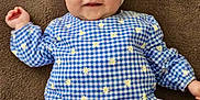 Lou participe au concours pour gagner de l'argent avec cette photo : baby, child, smiling, headband, bow, blue_dress, checkered_pattern, flowers, lying_down, brown_background, cute, infant, happy, clothing, portrait, young_child, indoors, person, head, face