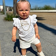 Lyna participe au concours pour gagner de l'argent avec cette photo : toddler, child, outdoor, sunny, sidewalk, white_clothing, shorts, sneakers, pony_tail, necklace, expression, determined, person, portrait, summer, daylight, casual, cute, fashion, walking