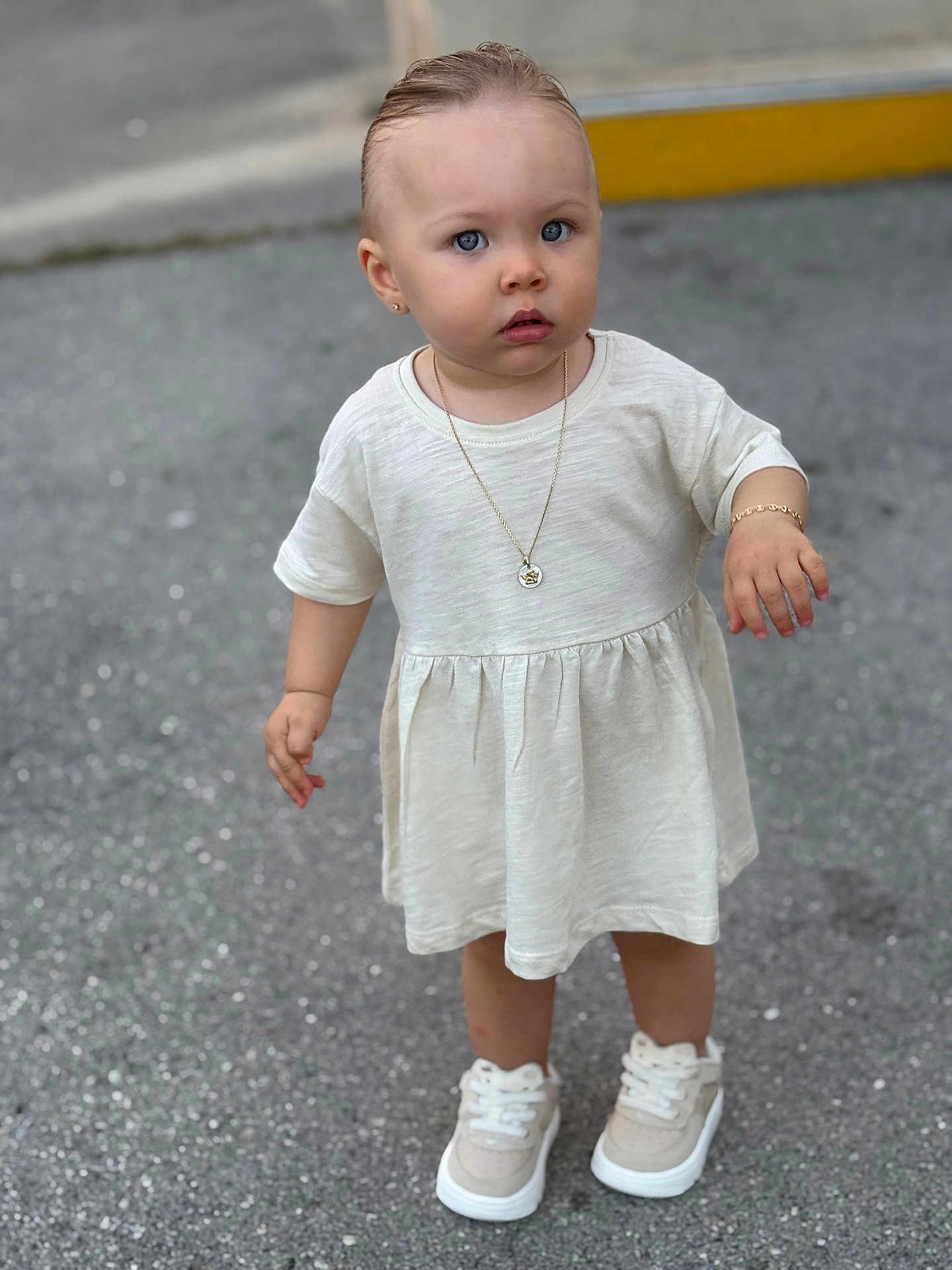 Lyna a rejoint le concours — aidez-le/la à gagner de superbes lots ! toddler, child, blue_eyes, dress, sneakers, jewelry, bracelet, necklace, earrings, outdoor, pavement, standing, curious, portrait, casual, fashion, young_child, person, footwear, daytime