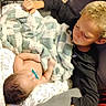 Leo is registered to the contest to win money with this photo: child, baby, infant, siblings, brother, sleeping, pacifier, blanket, cuddling, portrait, indoor, bedroom, chair, clothing, brown_hair, blond_hair, smiling, family, laundry_basket, hangers