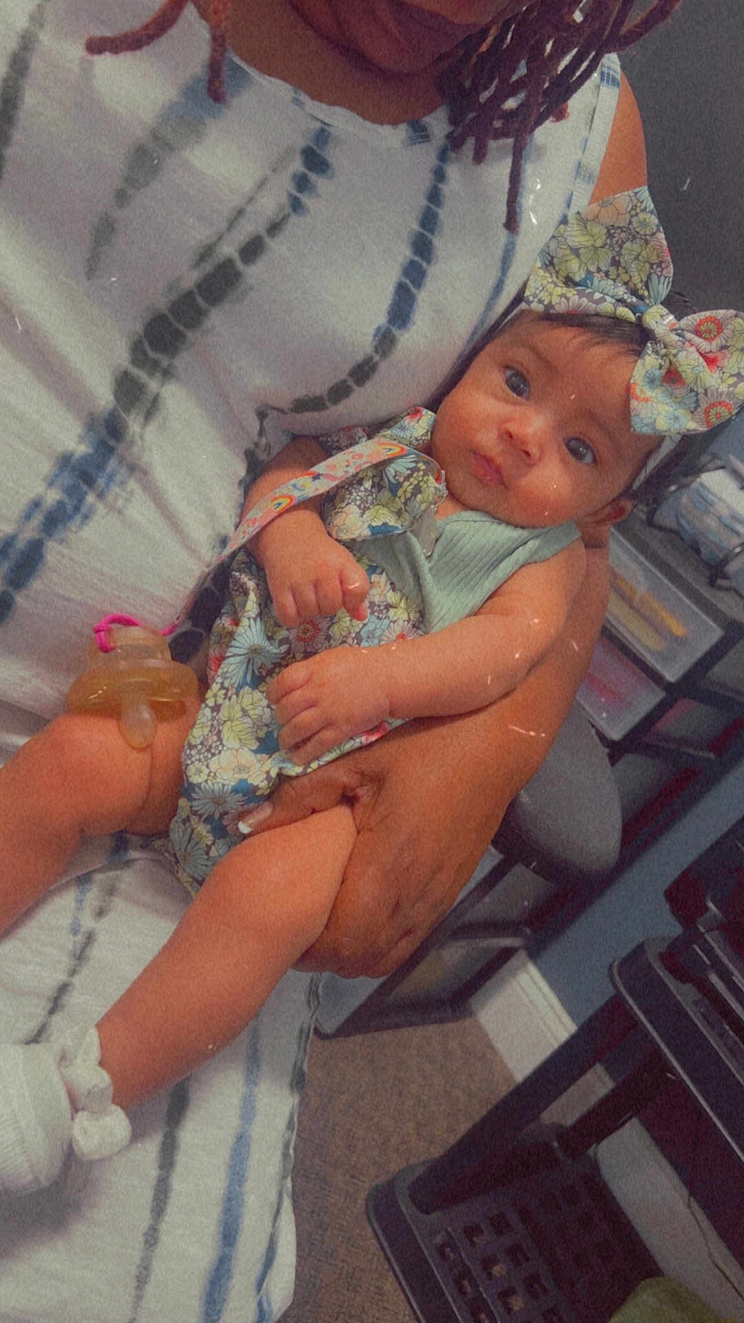 Janeishka joined the competition — help win amazing prizes! baby, child, adult, arms, bow, clothing, floral_pattern, hand, indoor, pacifier, person, portrait, seated, sitting, skin, table, toy, white_sock, woman, young_child