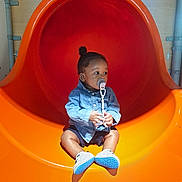 Ablet Prince Laël a rejoint le concours — aidez-le/la à gagner de superbes lots ! child, toddler, pacifier, denim_jacket, orange_slide, playground, shoes, indoor, curious, sitting, baby, shorts, toy, play, fun, young, cute, leisure, person, slide