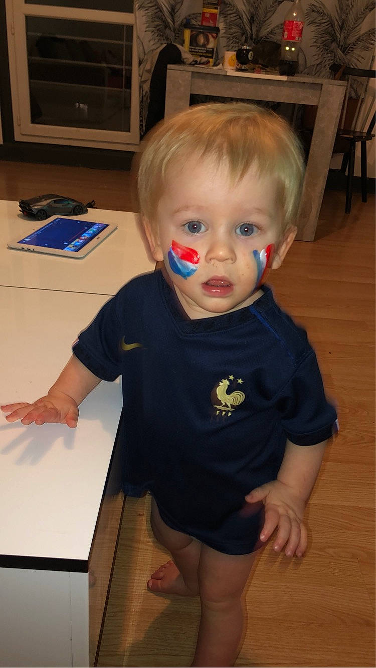 Giovanni a rejoint le concours — aidez-le/la à gagner de superbes lots ! baby, baby_toddler_clothing, chair, cheek, child, electric_blue, floor, flooring, fun, hardwood, iris, person, room, shorts, sitting, sleeve, t_shirt, thigh, toddler, varnish