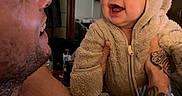 Phoenix joined the competition — help win amazing prizes! baby, infant, child, adult, father, smiling, laughing, portrait, indoor, home, bear_costume, hood, fuzzy_clothing, tattoo, beard, face, family, holding, interaction, photograph