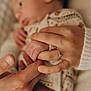 Antoine participe au concours pour gagner de l'argent avec cette photo : baby, hand, finger, adult, ring, holding, closeup, skin, warmth, intimacy, blurred_background, soft_light, cuddling, family, love, infant, clothing, pattern, cozy, touch