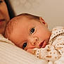 Antoine participe au concours pour gagner de l'argent avec cette photo : baby, newborn, infant, face, close_up, soft_lighting, warm_tones, cozy, snuggling, person, portrait, cute, sleepy, clothing, patterned_outfit, skin, head, expression, comfort, indoor