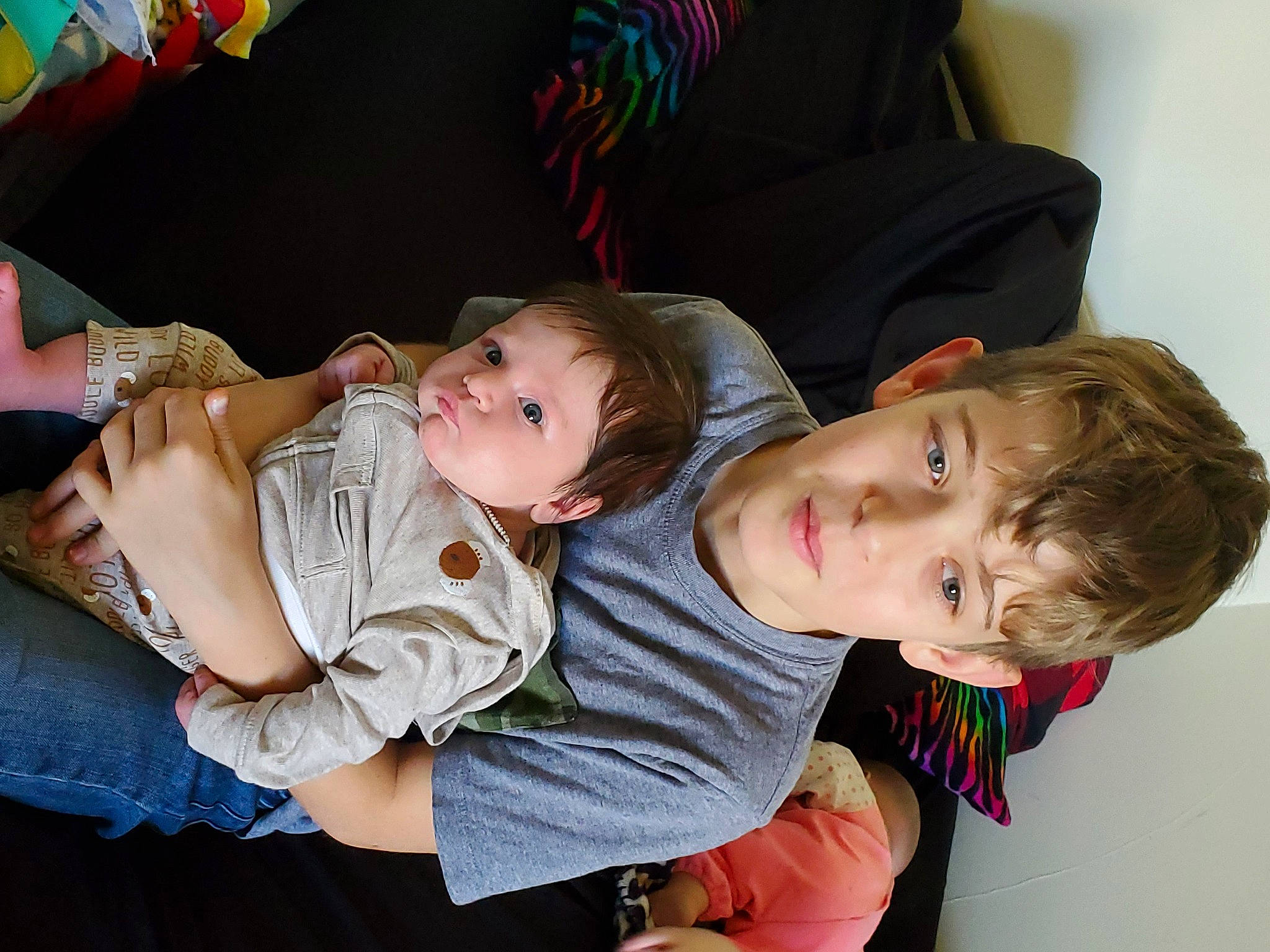 Erich is registered to the contest to win money with this photo: arm, baby, baby_products, baby_toddler_clothing, cheek, child, comfort, event, finger, fun, hairstyle, happy, interaction, lap, organ, person, room, sibling, sitting, toddler