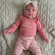 Eren joined the competition — help win amazing prizes! apparel, baby, blanket, bow, child, cozy, cute, expression, face, headband, indoors, infant, long_sleeve, lying_down, patterned_pants, person, pink_clothing, portrait, soft_texture, young_child