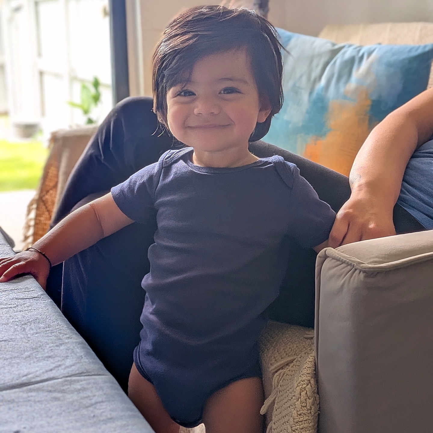 Shawnak joined the competition — help win amazing prizes! toddler, child, smiling, indoor, living_room, couch, pillow, lamp, table, natural_light, happy, person, short_sleeves, dark_hair, standing, home, cozy, casual_clothing, portrait, furniture