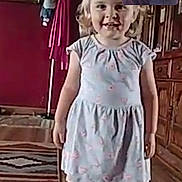 Denver is registered to the contest to win money with this photo: child, girl, dress, indoor, floor, wooden_floor, smiling, video_call, woman, hair, furniture, cabinet, rug, painting, coat_rack, shoes, happy, home, portrait, family