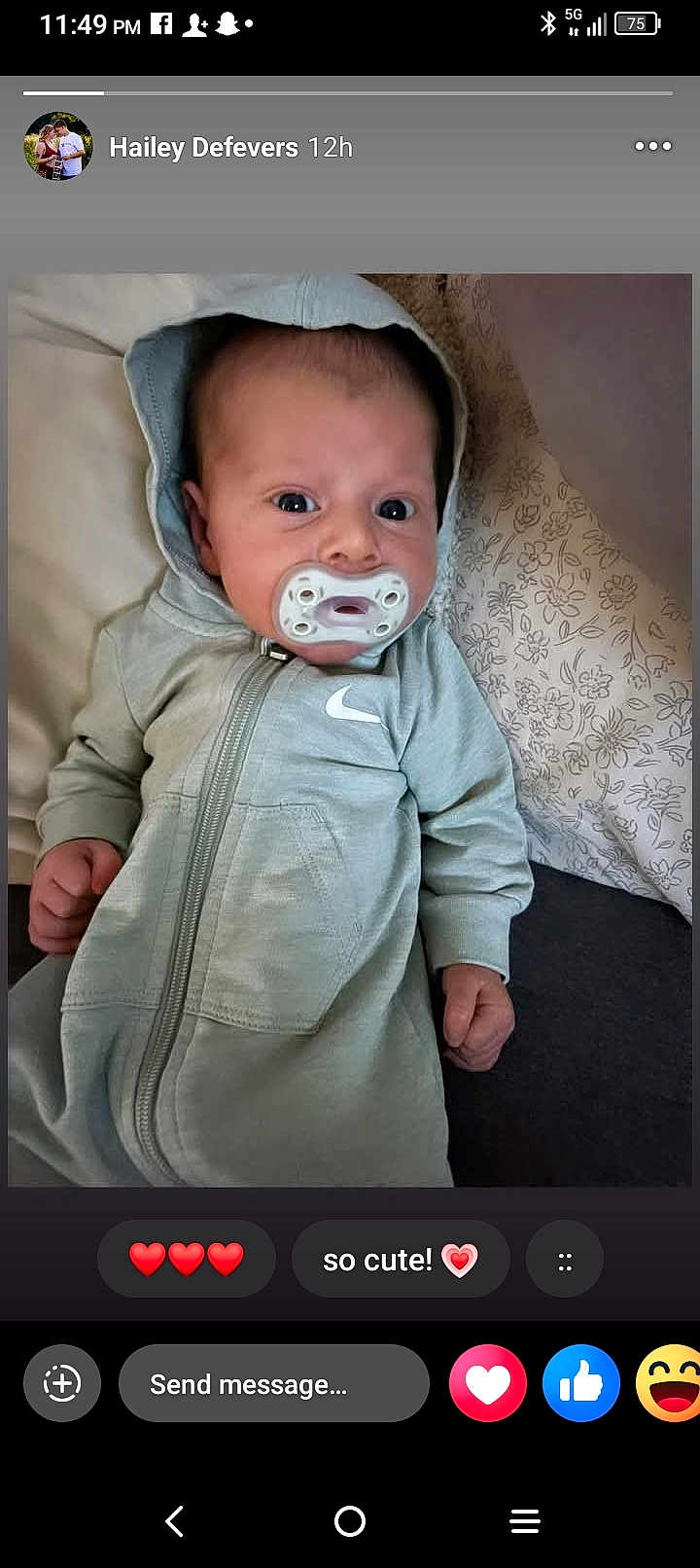 Carter is registered to the contest to win money with this photo: baby, infant, pacifier, hoodie, gray_clothing, lying_down, pillow, floral_pattern, face, wide_eyes, cute, indoors, person, child, young_baby, casual_wear, portrait, expression, cozy, closeup