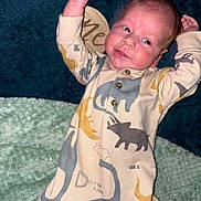 Carter joined the competition — help win amazing prizes! baby, infant, pajamas, dinosaur, blanket, soft_texture, smile, face, raised_arms, wooden_sign, curious, indoors, cozy, child, cute, sleepwear, lying_down, newborn, clothing, person