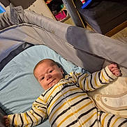 Mael participe au concours pour gagner de l'argent avec cette photo : baby, crib, blanket, onesie, striped_clothing, infant, bedroom, baby_gear, soft_fabric, face, person, child, furniture, flooring, home_interior, comfort, lying_down, cute, smile, young_child