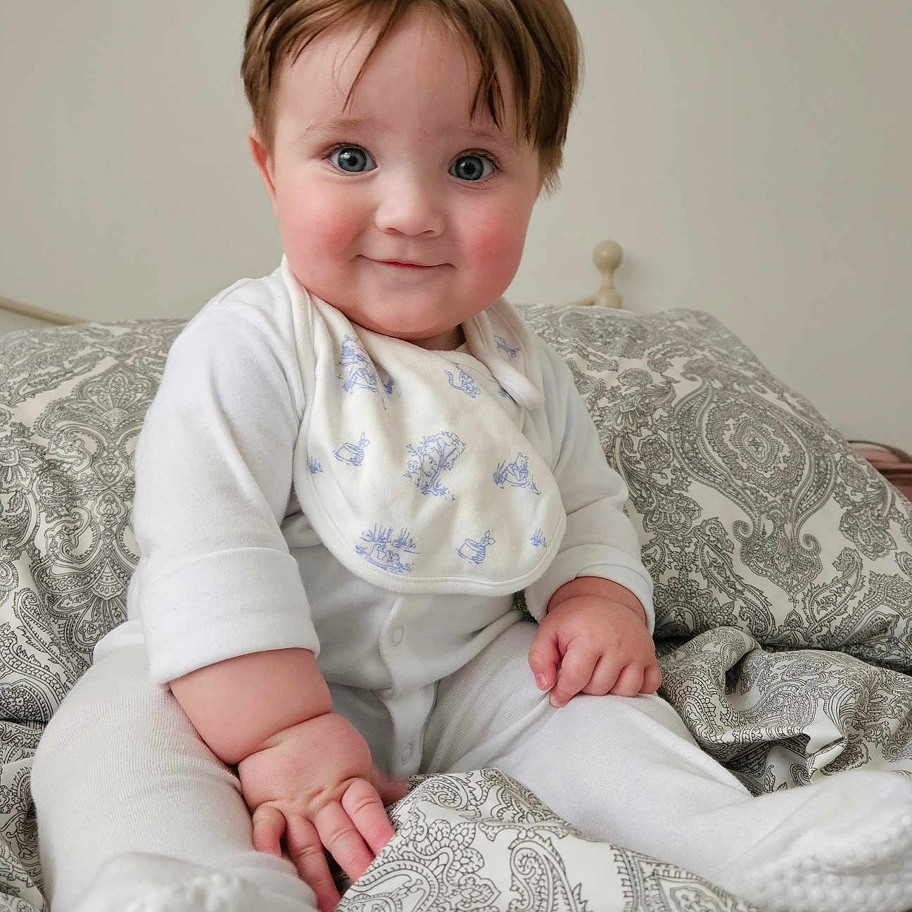 Harry joined the competition — help win amazing prizes! baby, bed, bib, blanket, blue_eyes, child, chubby_cheeks, cozy, cute, happy, indoors, infant, patterned, person, portrait, sitting, smile, soft_lighting, tousled_hair, white_pajamas
