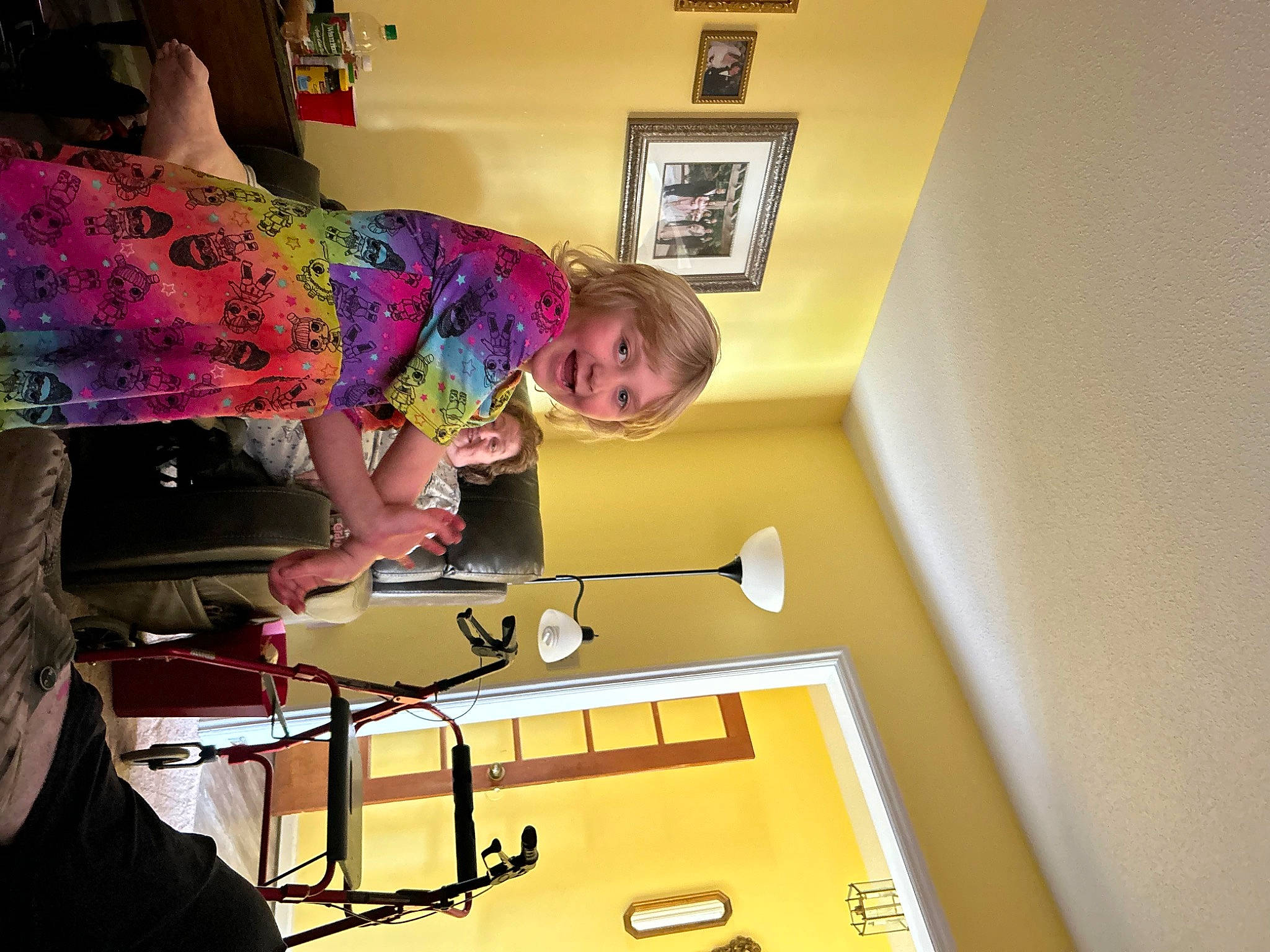 Taylor is registered to the contest to win money with this photo: ceiling, child, desk, eyewear, fashion_design, flooring, fun, house, joy, lighting_accessory, magenta, person, picture_frame, room, shelf, smile, t_shirt, table, visual_arts, wood