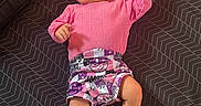 Summer joined the competition — help win amazing prizes! baby, child, infant, pink_sweater, shorts, playpen, toys, lying_down, raised_hand, wide_eyed, portrait, indoor, patterned_blanket, geometric_pattern, clothing, bare_feet, happy, cute, photography, home