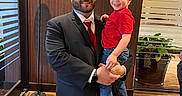 Haydn joined the competition — help win amazing prizes! beard, carpet, casual, child, formal, glass, happy, holding, indoor, jeans, lamp, man, people, plant, portrait, red_shirt, smile, suit, window, wood_floor
