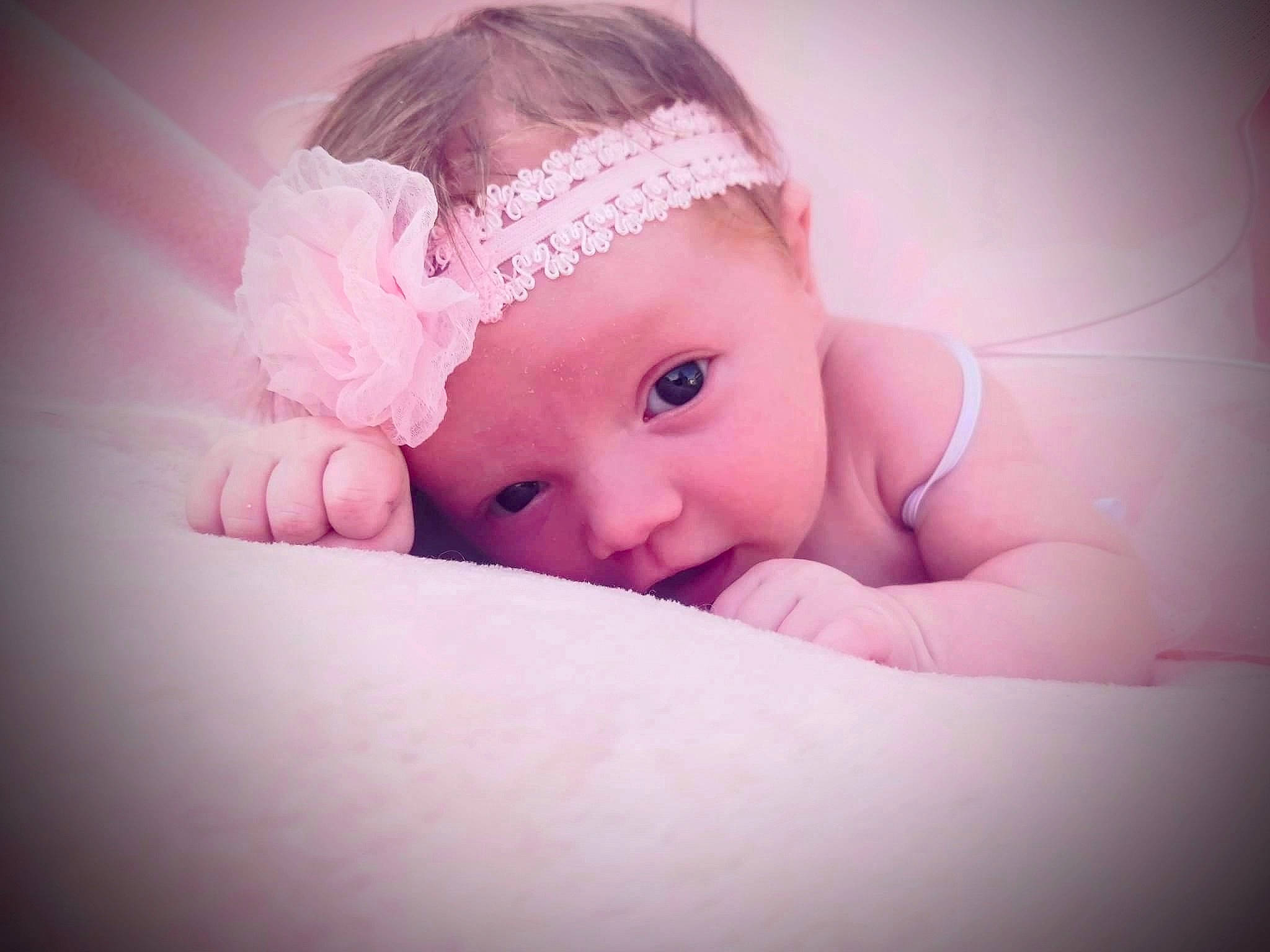 Melanie is registered to the contest to win money with this photo: baby, baby_toddler_clothing, cap, cheek, ear, eyebrow, fashion_accessory, flash_photography, grass, hair_accessory, happy, headband, headgear, headpiece, headwear, iris, lip, magenta, nail, person