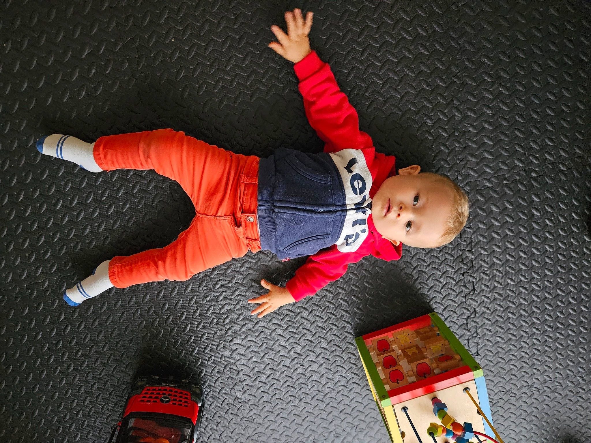 Maylon a rejoint le concours — aidez-le/la à gagner de superbes lots ! baby_toddler_clothing, carmine, child, entertainment, fictional_character, flooring, fun, orange, person, play, room, sleeve, sportswear, t_shirt, toddler, toy, walking_shoe