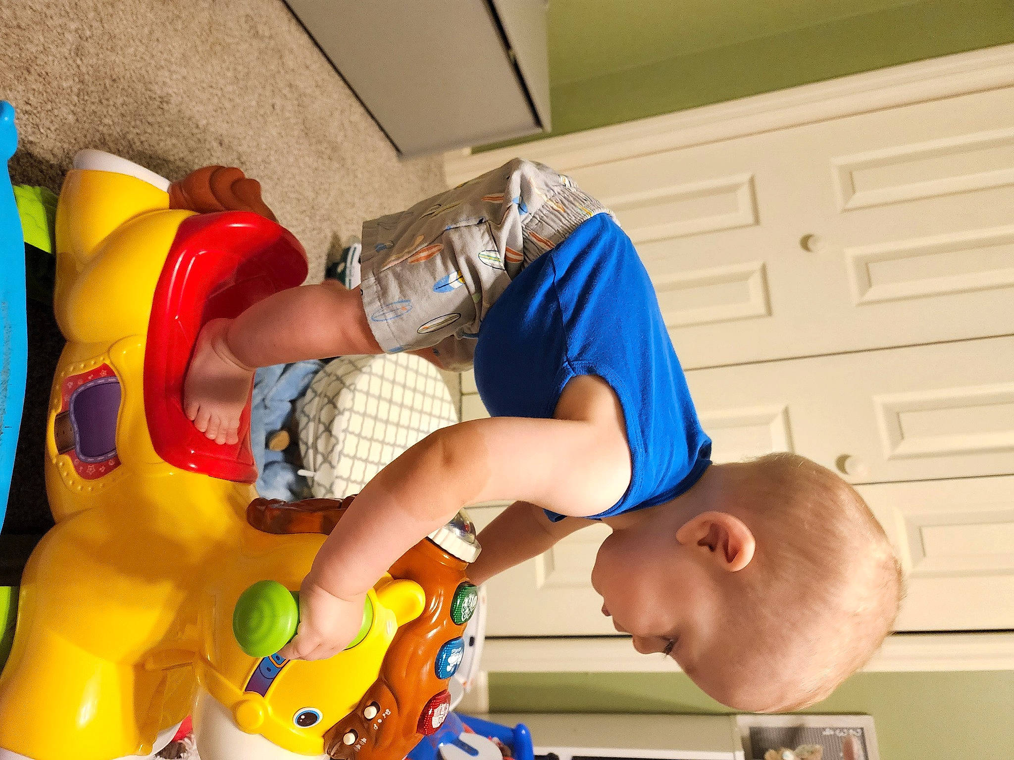 Holden is registered to the contest to win money with this photo: arm, baby, baby_products, baby_toddler_clothing, baby_toys, child, fun, happy, hat, human_leg, leisure, orange, person, play, room, shorts, sitting, thigh, toddler, toy