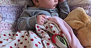 Miyu is registered to the contest to win money with this photo: baby, bed, blanket, child, closed_eyes, cozy, face, gray_clothing, indoors, infant, lying_down, nursery, peaceful, pink_blanket, portrait, quilt, sleeping, strawberry_pattern, stuffed_animal, teddy_bear