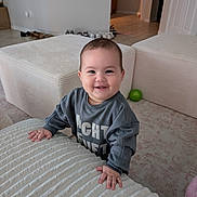 Miyu is registered to the contest to win money with this photo: baby, blanket, child, couch, furniture, gray_shirt, green_ball, hallway, happy, home, indoors, infant, living_room, ottoman, photography, portrait, shoes, sitting, smiling, standing