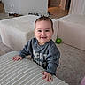 Miyu is registered to the contest to win money with this photo: baby, blanket, child, clothing, face, furniture, green_ball, happy, home, indoor, infant, living_room, photography, portrait, quilt, sitting, smiling, sofa, standing, sweatshirt