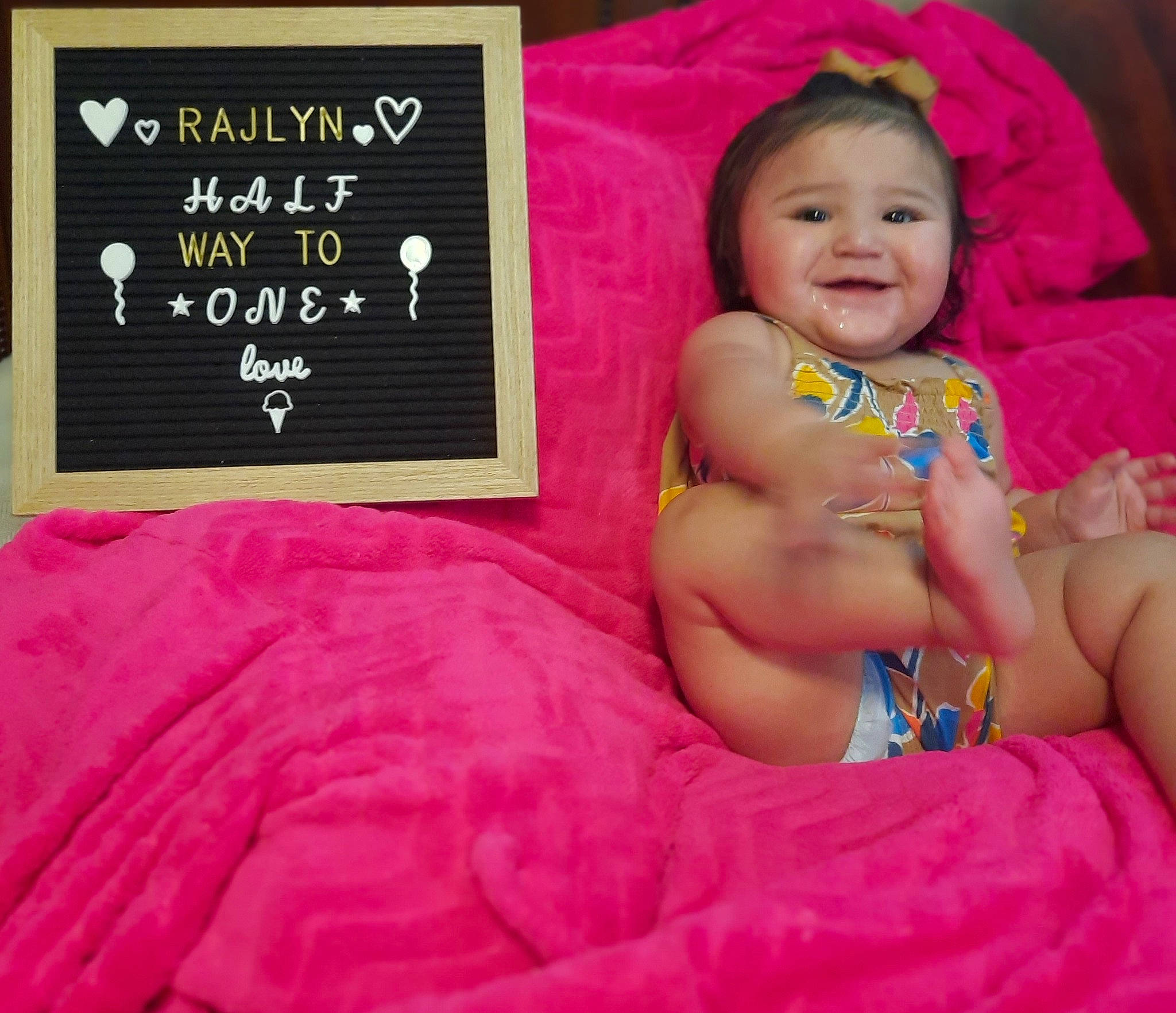 Rajlyn is registered to the contest to win money with this photo: abdomen, baby, baby_laughing, baby_products, baby_toddler_clothing, blackboard, child, comfort, finger, font, happy, joy, linens, magenta, pattern, person, photo_caption, pink, room, smile