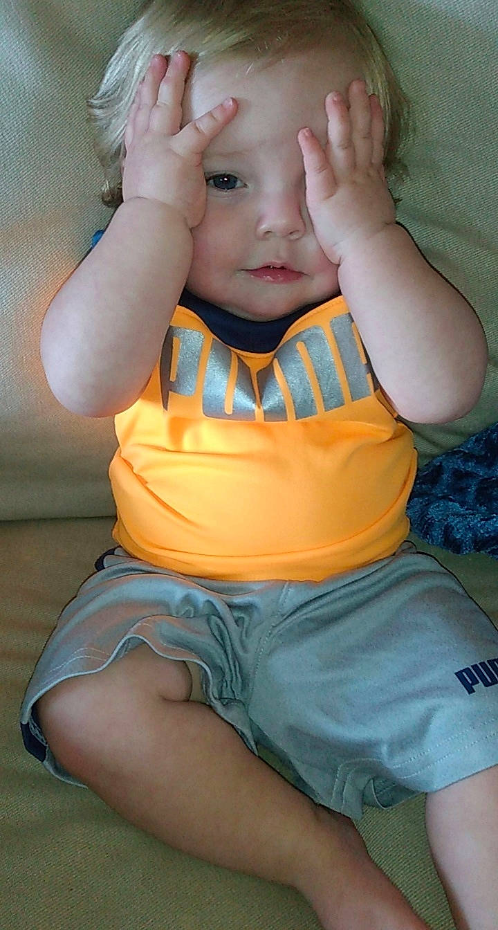 Eli is registered to the contest to win money with this photo: baby_toddler_clothing, chest, chin, elbow, eye, eyelash, finger, gesture, hair, happy, head, human_body, mouth, muscle, neck, orange, person, shorts, skin, sleeve