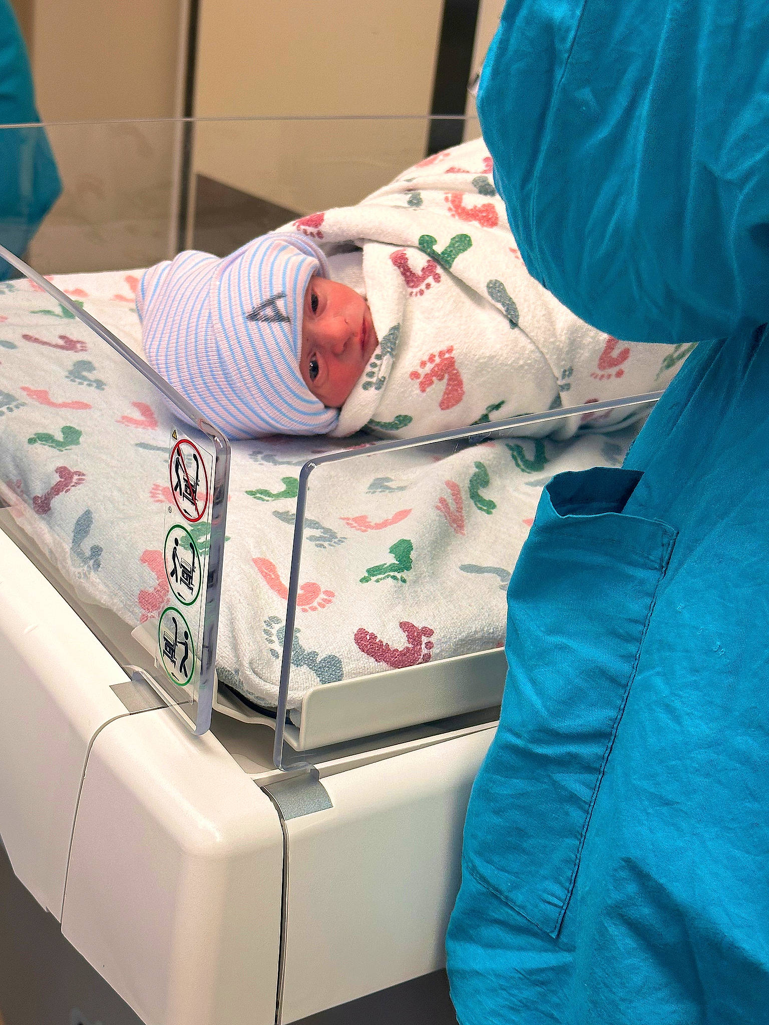 Lincoln is registered to the contest to win money with this photo: baby, baby_products, baby_toddler_clothing, blue, child, comfort, electric_blue, headwear, health_care, hospital, lap, linens, medical, nap, person, room, service, sitting, sleep, textile