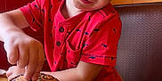 Ronan is registered to the contest to win money with this photo: booth, boy, burger, casual_dining, cheese, child, cute, fast_food, food, fries, happy, indoor, meal, red_shirt, restaurant, shark_print, smiling, table, tomato, wooden_table