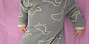 Millie is registered to the contest to win money with this photo: baby, infant, onesie, duck_pattern, pink_blanket, lying_down, cute, smiling, child, soft_texture, sleepwear, portrait, young_child, indoors, playful, baby_clothes, human, face, small_hands, cozy