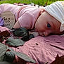 Annie is registered to the contest to win money with this photo: baby, infant, one_month, headband, pink_clothing, blanket, leaves, outdoor, nature, portrait, face, closeup, blue_eyes, wooden_sign, flower, soft_texture, newborn, cute, lying_down, child