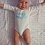 baby, infant, smile, blue_headband, white_onesie, cookie_monster_text, blanket, love_text, happy, cute, lying_down, arms_outstretched, socks, child, portrait, indoor, face, skin, headwear, one_person